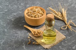 Fresh sprouted wheat seeds in bowl and spoon, ears, wheat germ oil in bottle. Source of vitamins and micronutrients, has general strengthening, immunostimulating, antibacterial, antioxidant properties