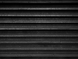 Old black metal wall. Striped background. Dark wallpaper