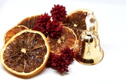 Christmas decorations closeup, golden bell, pines and oranges slices partially slightly unfocused . High quality photo