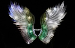 Illuminated angel wings on a black background. Selective focus. High quality photo
