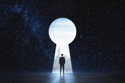 Back view of young businessman standing against keyhole door on starry sky background. Dream, success, opportunity and startup concept