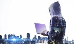 Side view of hacker with laptop computer on city background with copy space. Hacking and computing concept. Double exposure 