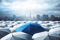 Blue umbrella on top of other gray umbrellas on city background. Business and safety concept