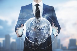 Businessman holding abstract digital globe on blurry city background. Communication concept. Double exposure