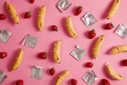 Super safe condoms of banana and strawberry flavor with pleasant smell on rosy studio background. Contraceptives made of natural rubber latex, high quality material. Natural feel and safety.