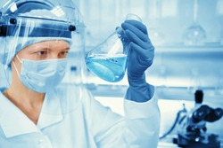 Closeup portrait female scientist holding conical tube with liquid solution, laboratory experiments, isolated lab background. Forensics, genetics, microbiology, biochemistry 