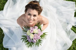 High View Portrait Of Beautiful Happy Bride Sitting On The Grass