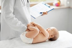 medicine, healthcare and pediatrics concept - female pediatrician or neuropathist doctor or nurse checking baby patient's at clinic or hospital