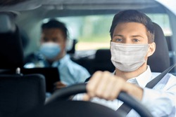 health protection, safety and pandemic concept - male taxi driver wearing face protective medical mask driving car with passenger