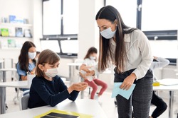 Teacher, children with face mask at school after covid-19 quarantine and lockdown.