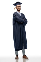 education, graduation and people concept - happy smiling male graduate student in mortar board and bachelor gown with crossed arms over white background