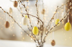 holidays and object concept - close up of pussy willow branches decorated by easter eggs over bokeh lights