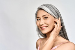 Portrait of gorgeous happy middle aged mature asian woman, senior older 50 year lady looking at camera touching her face isolated on white. Ads of lifting anti wrinkle skin care, spa. Copy space.