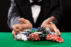 casino, gambling, poker, people and entertainment concept - close up of poker player with chips at green casino table