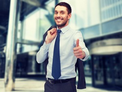 business and office concept - handsome buisnessman with jacket over shoulder showing thumbs up
