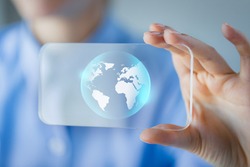 business, technology, international communication, mass media and people concept - close up of woman hand holding and showing transparent smartphone with globe on screen
