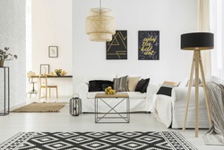 Bright room with white sofa, table, pattern carpet and lamp