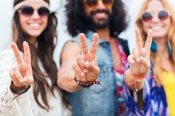 youth culture, gesture and people concept - smiling young hippie friends in sunglasses showing peace hand sign outdoors