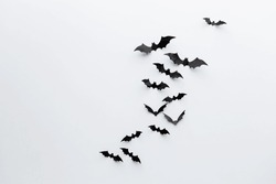 halloween and decoration concept - black paper bats flying over white background