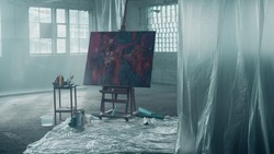 Isolated Abstract Painting in The Middle of an Empty Warehouse With Big Windows With Sun Shining Through Them.