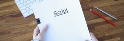 Screenwriter holds folder of documents labeled script