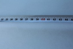 A white tape measure tool contains centimeters and millimeters
