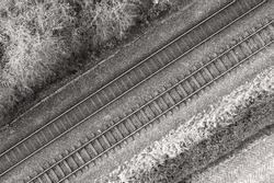 Black and white image of two railway tracks which consists of two parallel steel rails, anchored perpendicular to members called ties (sleepers) of concrete to maintain a consistent distance apart.