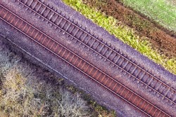 Romantic image of two railway tracks which consists of two parallel steel rails, anchored perpendicular to members called ties (sleepers) of concrete to maintain a consistent distance apart. Pattern.
