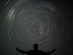 Man Pointing in a spiral star trail