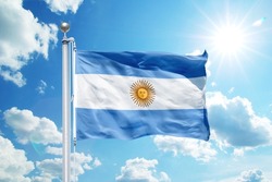 National Argentina flag waving in the wind, against the blue sky. Wavy flag in the sky with sunbeams.