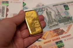 Russian rubles banknotes with gold bullion bar. Gold backed financial system of Russia. Russian gold reserves. De-dollarization. World monetary system.