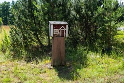Cute letter box that looks like a small wooden house. Creative mailbox in rural area. Post delivery and postal service in countryside concept. 