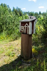Cute letter box that looks like a small wooden house. Creative mailbox in rural area. Post delivery and postal service in countryside concept. 