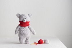 Crochet knitting cute teddy bear with a red scarf