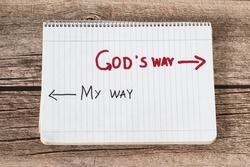 God's way, a handwritten text quote and arrows in a white notebook page placed on a wooden background. Follow the way of life with obedience to God Jesus Christ, biblical concept. Top view.	