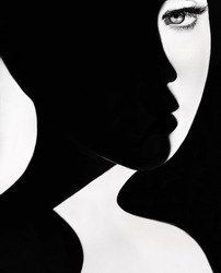 High contrast black and white portrait of a beautiful girl. Girl's face with shadow. Good and evil concept. Fine art concept. Fashion portrait. Dark side person. Good and bad concept. beauty portrait