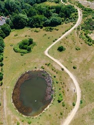Aerial view of a pond created from the void left by removing fuel storage wells at ex RAF Greenham Common