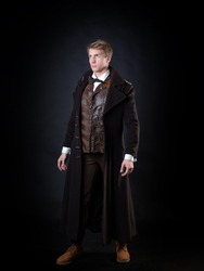the character of the steampunk story, a young attractive man in an elegant long coat. intelligent gentleman in the Victorian style. Vintage retro suit, young attractive man in a vest and bow tie