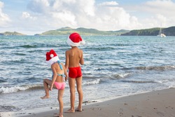 boy and girl in xmas hats on the summer bank