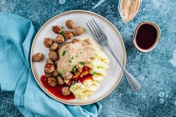 Swedish meatballs kottbullar, mashed potato, onion sauce and lingonberry sauce. Blue stone background. Top view