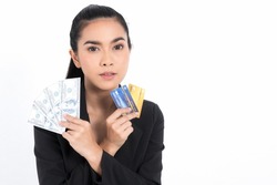 Portrait asian business woman with showing bunch of money banknotes and holding credit card in hand isolated on white background. Concept business and credit.
