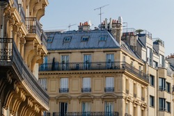 Paris residential buildings. Old Paris architecture, beautiful facade, typical french houses on sunny day. Famous travel destinations in Europe. City life, lifestyle and expensive real estate concept.