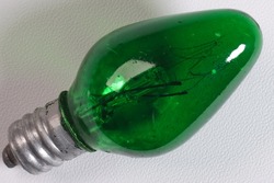 Green incandescent lamp with 5 watts of power on isolated white background
