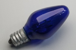Blue incandescent lamp with 5 watts of power on isolated white background