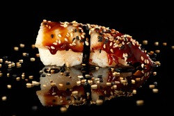 Japanese Cuisine - Appetizing Salmon Sushi Set, Nigiri. Philadelphia Sushi Roll - Maki Sushi with Philadelphia Cheese inside on mirror black background. Smoked salmon rolls served on a plate
