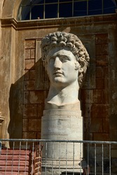 head of the emperor Caesar Octavian Augustus on pedestal illuminated from the side by the sun