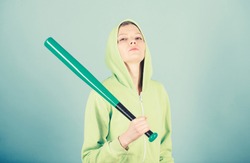 Girl hooded jacket hold baseball bat blue background. Woman in baseball sport. Baseball female player concept. She is dangerous. Girl troublemaker. Woman play baseball game or going to beat someone.