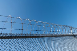 barbwire prison wall with barbed wire fence coiled razor wire perimeter fence with nobody, jail wall