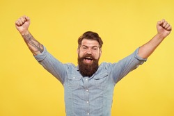 True victory not easy to achieve in life. Happy hipster with raised hands yellow background. Bearded man celebrate victory. Enjoying victory. Victory or success. Hes champion