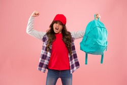 Powerful kid. Carrying things in backpack. Learn how fit backpack correctly. Girl little fashionable kid carry backpack. Useful fashion accessory. Schoolgirl red cap long hair with school backpack